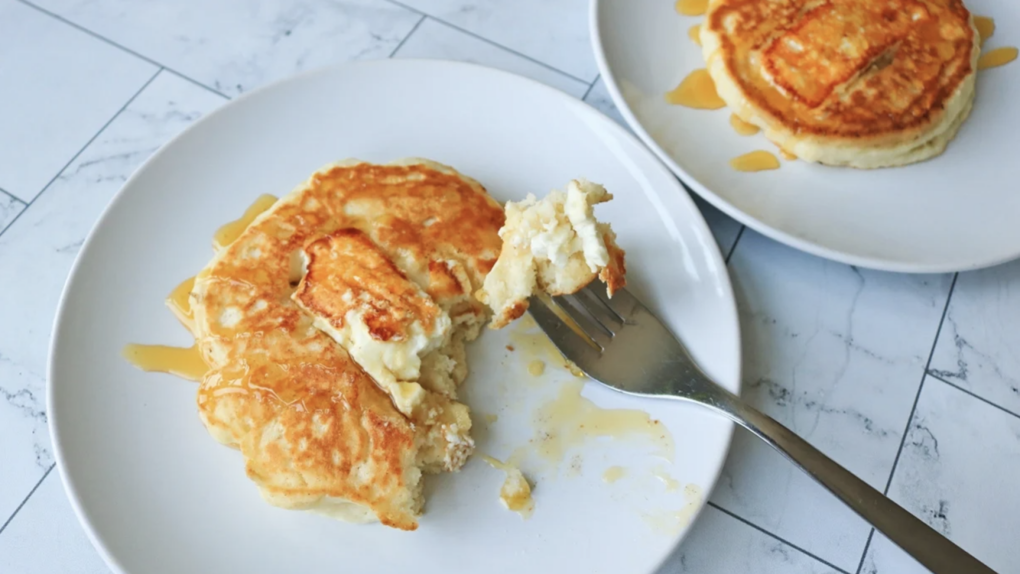 A feta pancake with honey on a plate with a fork.
