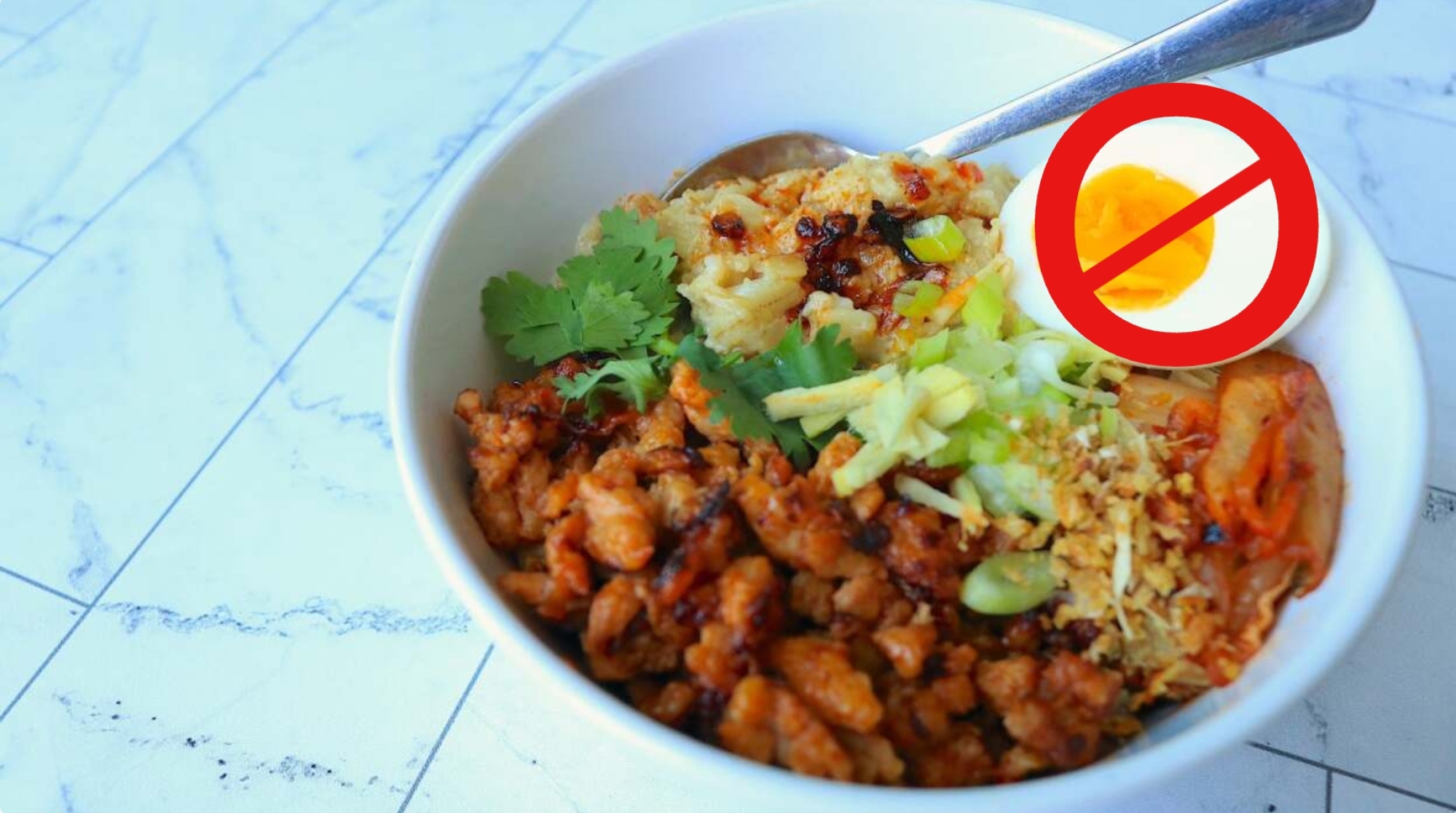 A bowl of savory oats with a red "no" symbol over the egg.